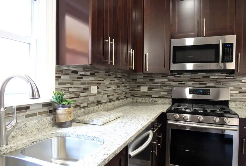 Kitchen with glass mosaic backsplash and stainless steel double sink