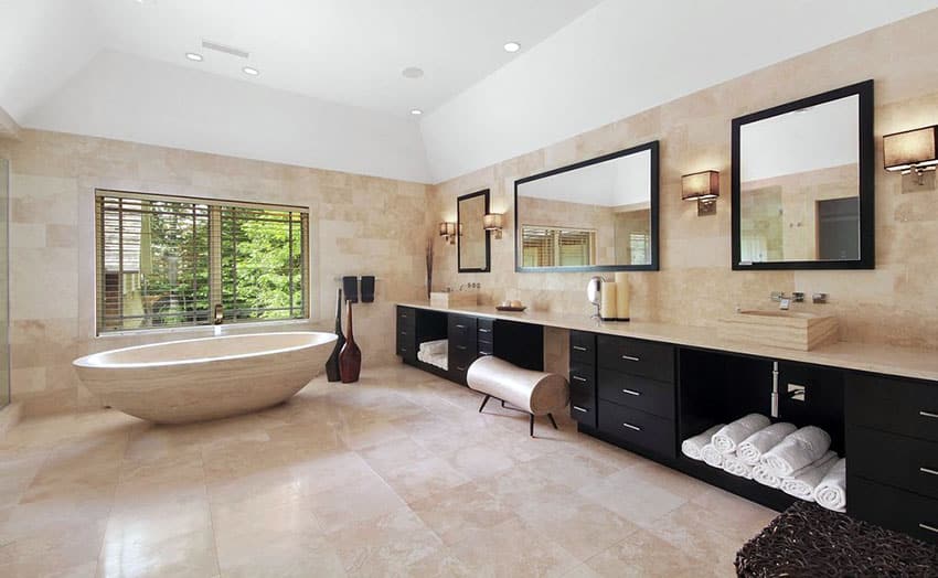 Bathroom with travertine tiles, soaking tub and vanity in dark finish