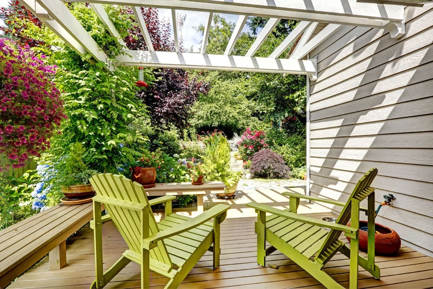 Deck pergola with green adirondack chairs