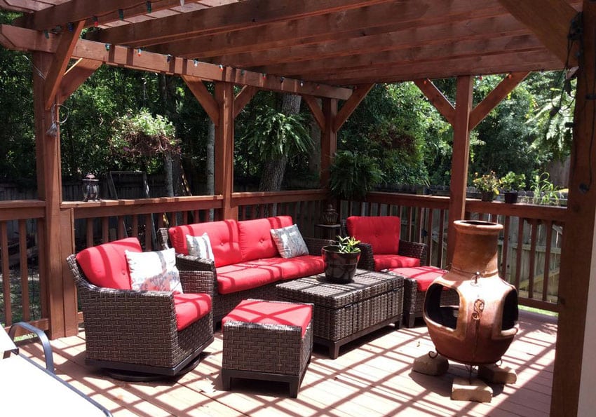 Pergola with furniture with red cushions and portable fireplace