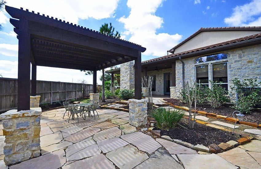 Large dark wood pergola with stone foundation and flagstone floors