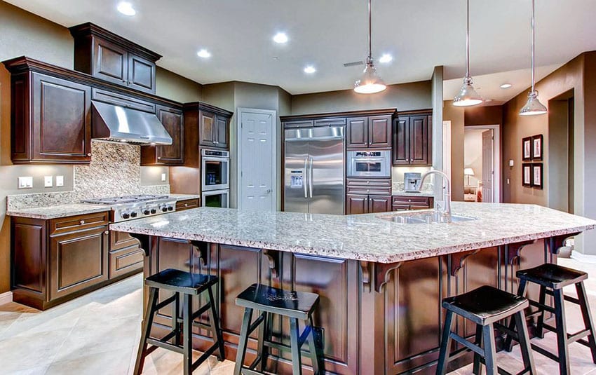 Kitchen with dark wood cabinets with antico cream light beige granite