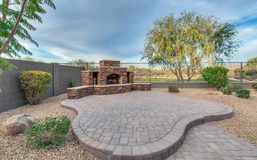 Large concrete rundle stone paver patio with outdoor fireplace