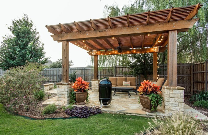 Large pergola with string lights above flagstone patio