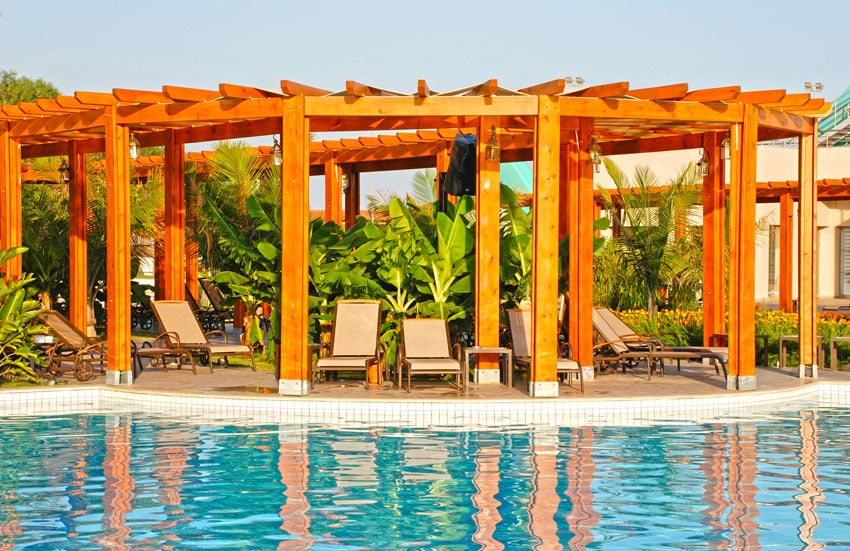 Semi covered orange cypress pergola with greneery in the middle