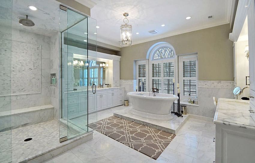 Bathroom with dual side tub, white vanity and marble counters & floors