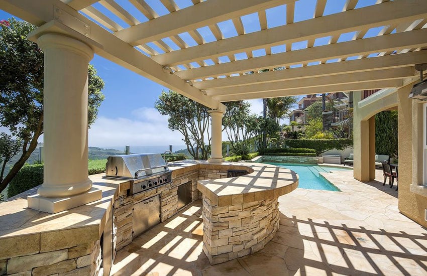 mediterranean style patio with outdoor kitchen and covered pergola