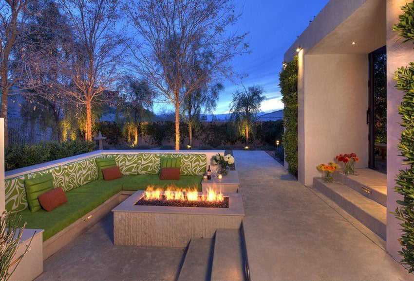 Modern backyard patio with l shaped concrete bench around firepit