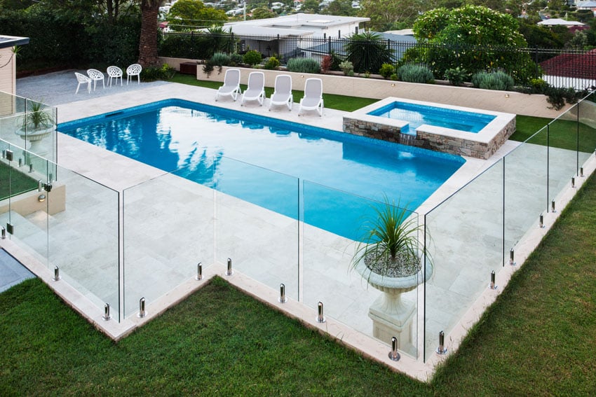 Modern fence made of glass surrounding pool