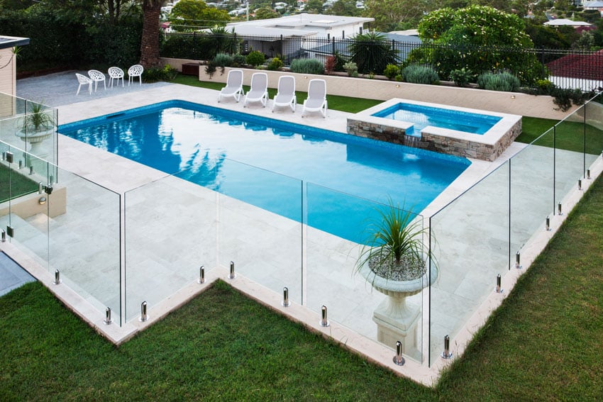 Modern fence made of glass surrounding pool 