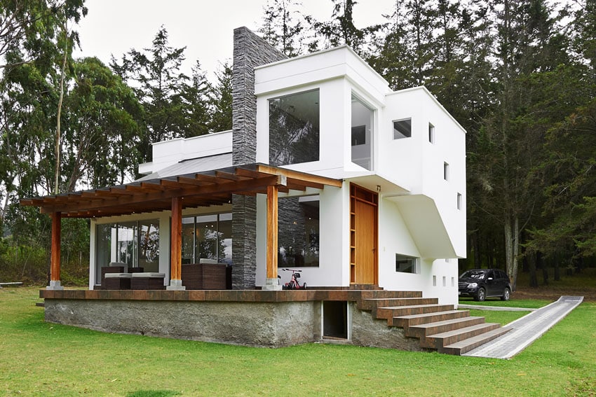 Covered pergola with teakwood beams and attached to the exterior wall of the house 