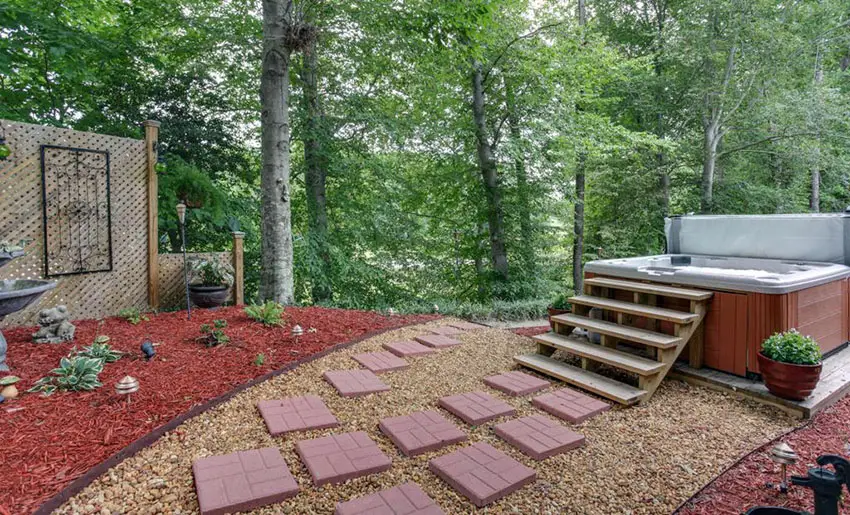 Red patio stone and pea gravel walkway to spa