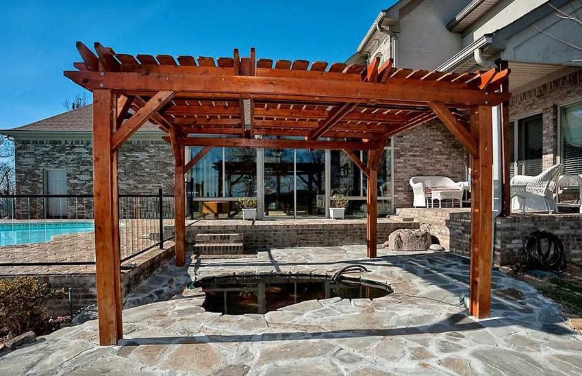 Redwood pergola on flagstone paved patio with small pond