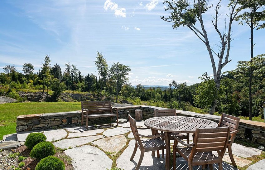 Rustic patio with golden white flagstones and wood outdoor dining table