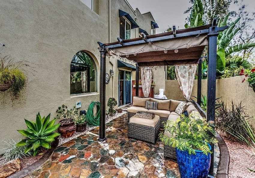 Rustic pergola cabana with curtains and large couch