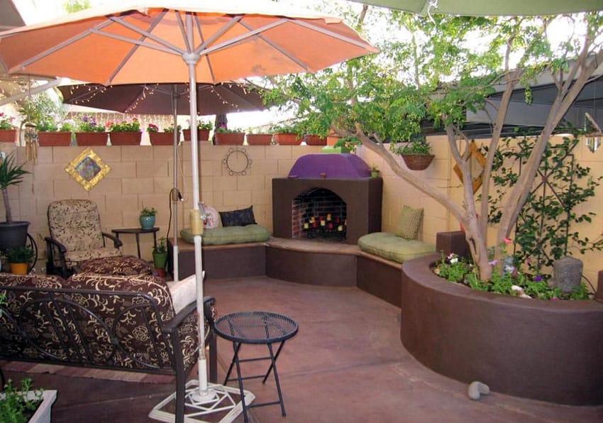 South western style patio with outdoor fireplace and custom concrete bench with cushions