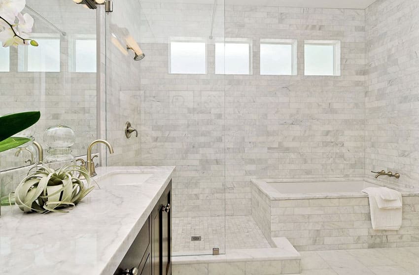 White master bathroom with marble vanity counter and marble shower surround tile