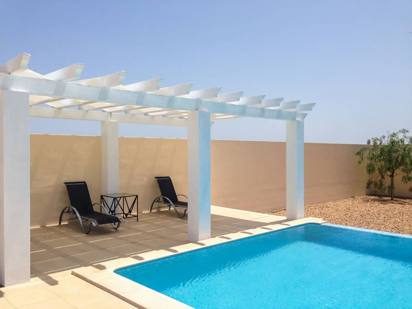 Pergola with square columns beside a pool