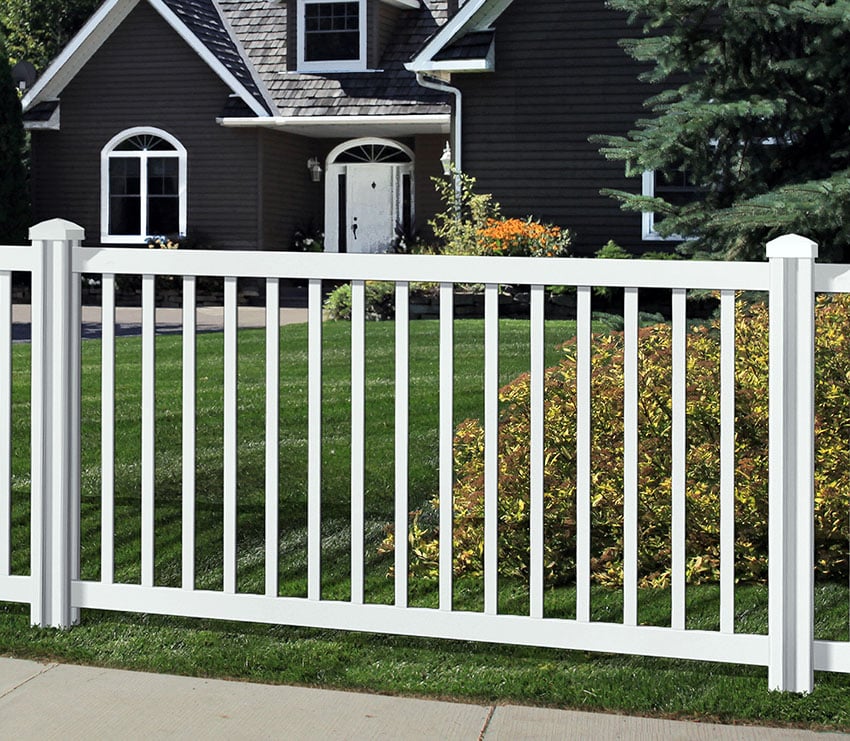 White fence and a cottage with wide lawn