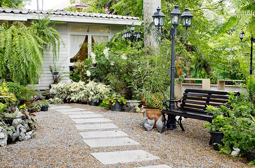 Concrete stone walkway with gravel pebble patio and park bench