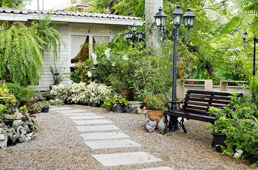 Concrete stone walkway with pebble patio and park bench