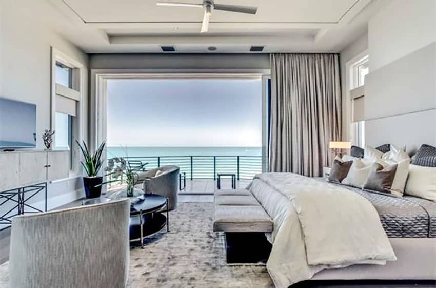 Contemporary bedroom with ocean views and large sliding door to outside balcony