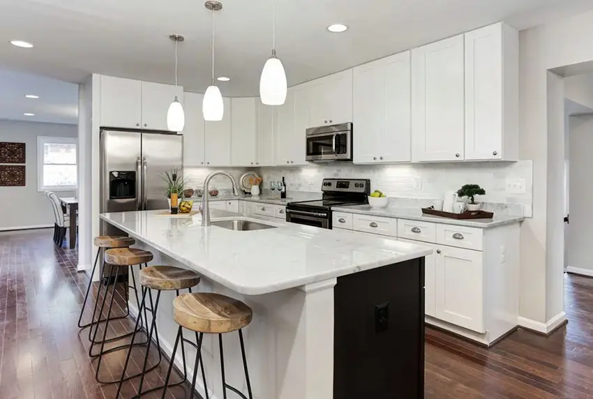 Contemporary kitchen with white cabinets carrara white countertops and matching subway tile backsplash