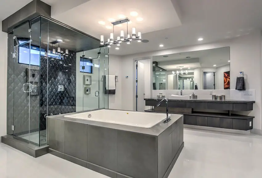 Gray bathroom with wide mirrors, enclosed bathtub and black tile shower 