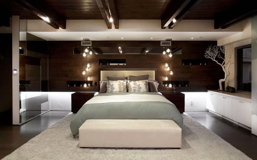 Contemporary master bedroom with leather headboard pendant lights and brown color palette