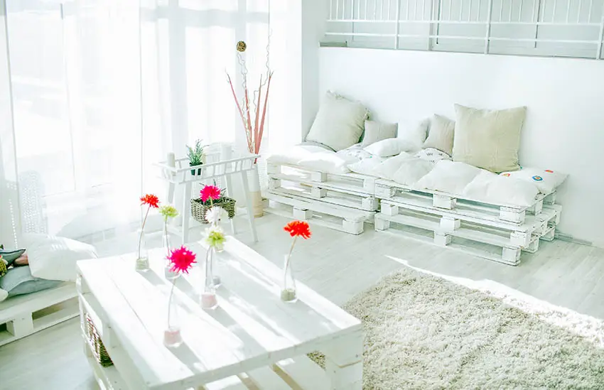 Pallet daybed with cushions, flowers and table