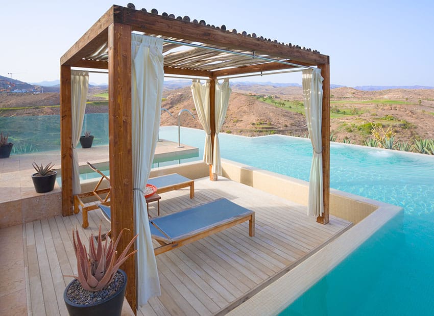 Exotic swimming pool cabana with lounge chairs