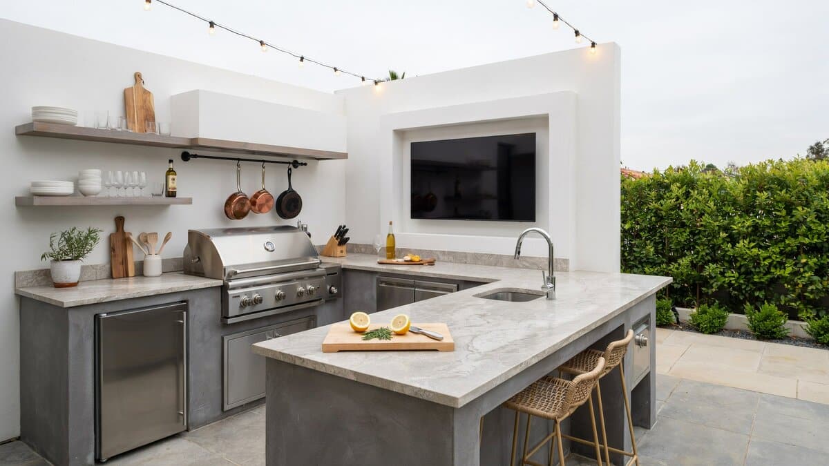U-shaped outdoor kitchen with slate counters and a recessed flat screen television