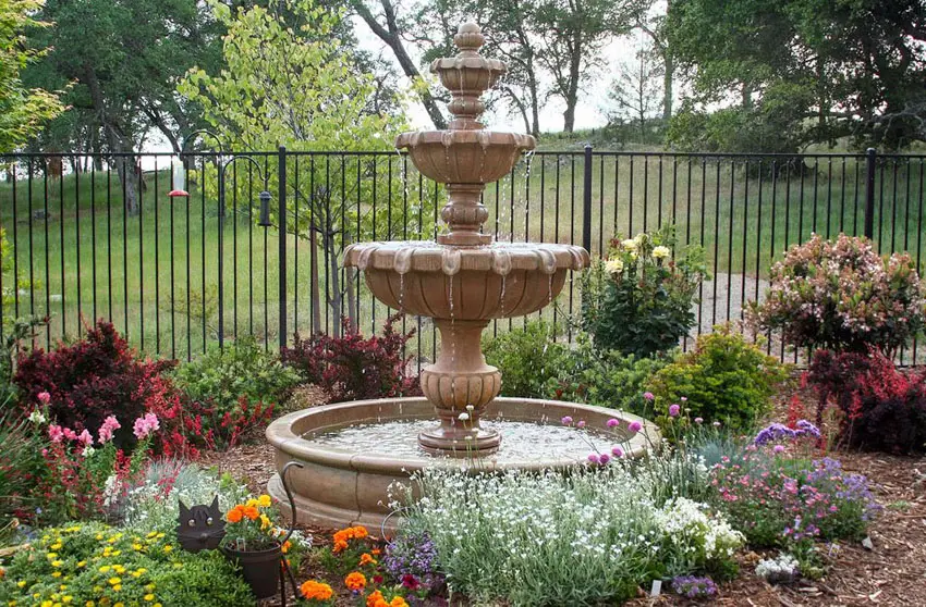 Garden with stone fountain and metal fence
