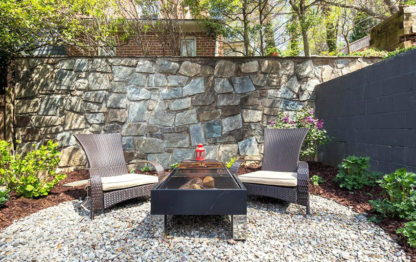 Stone wall and dark plastic rattan chair
