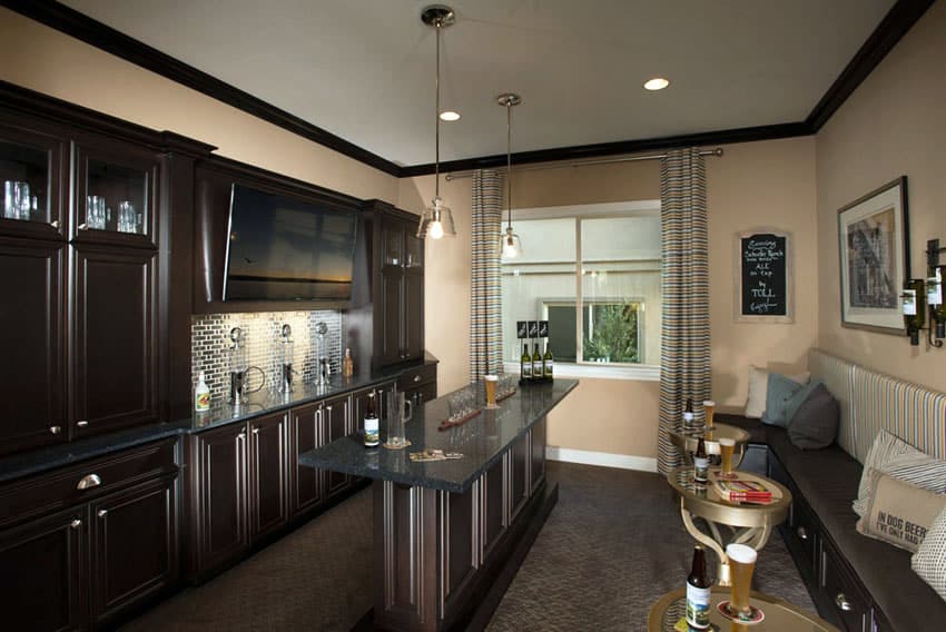 home bar with dark wood cabinets and bench seating