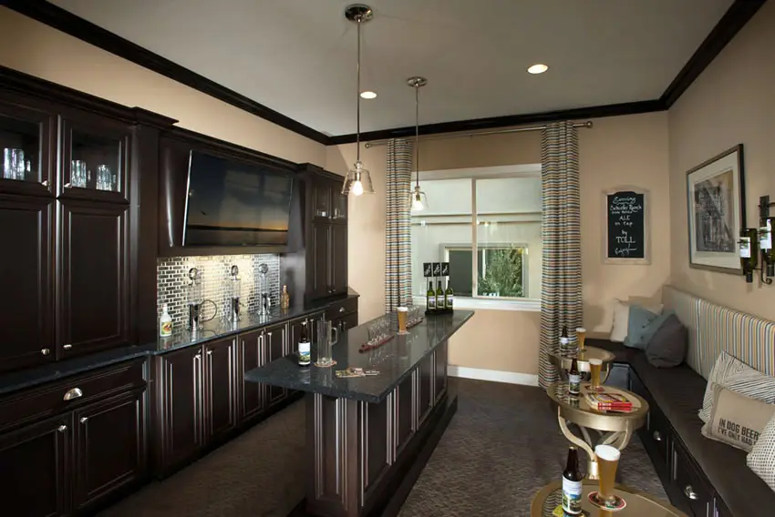 Home bar with dark wood cabinets and bench seating