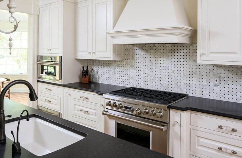 Kitchen with black granite counter and white basketweave backsplash tile and white cabinetry