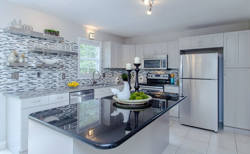 Kitchen with a finish in black satin granite and mosaic backsplash