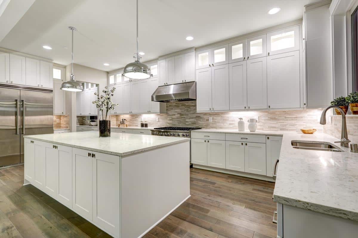 kitchen with cabinets light countertops chrome pendant lighting wood floors