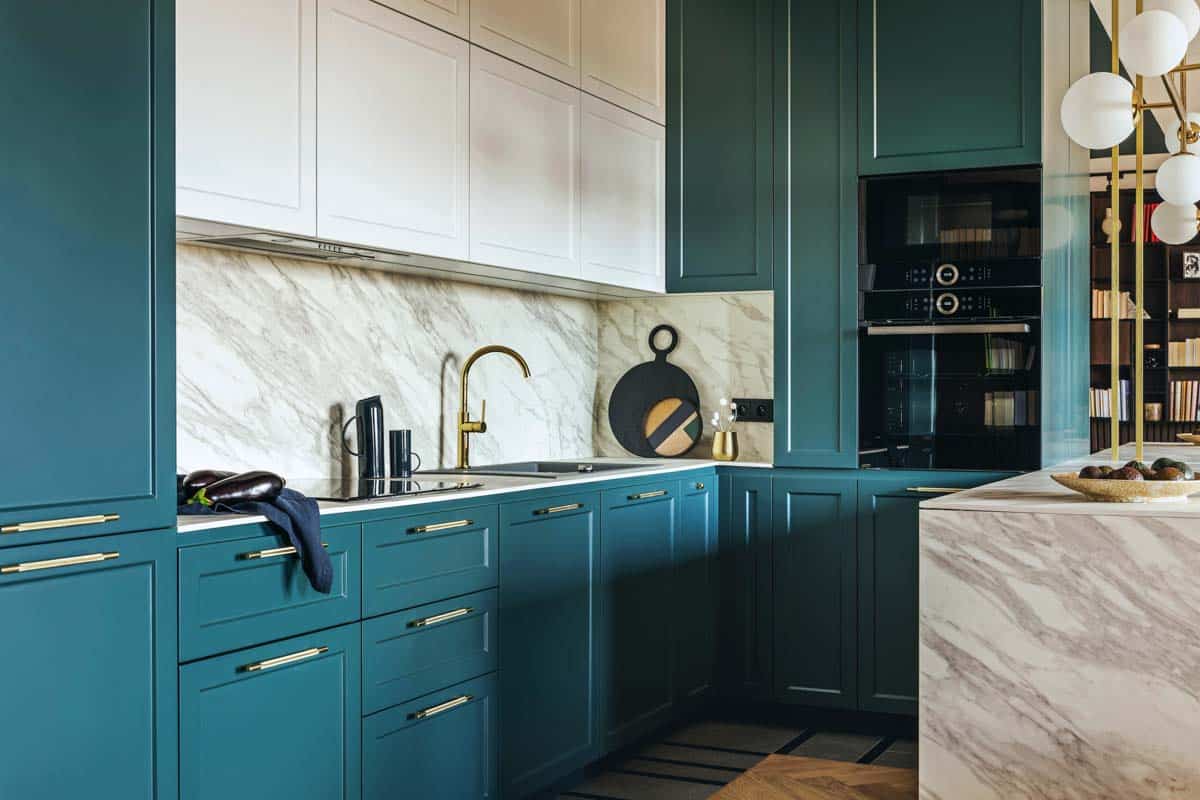 kitchen with green cabinets and backsplash made of marble