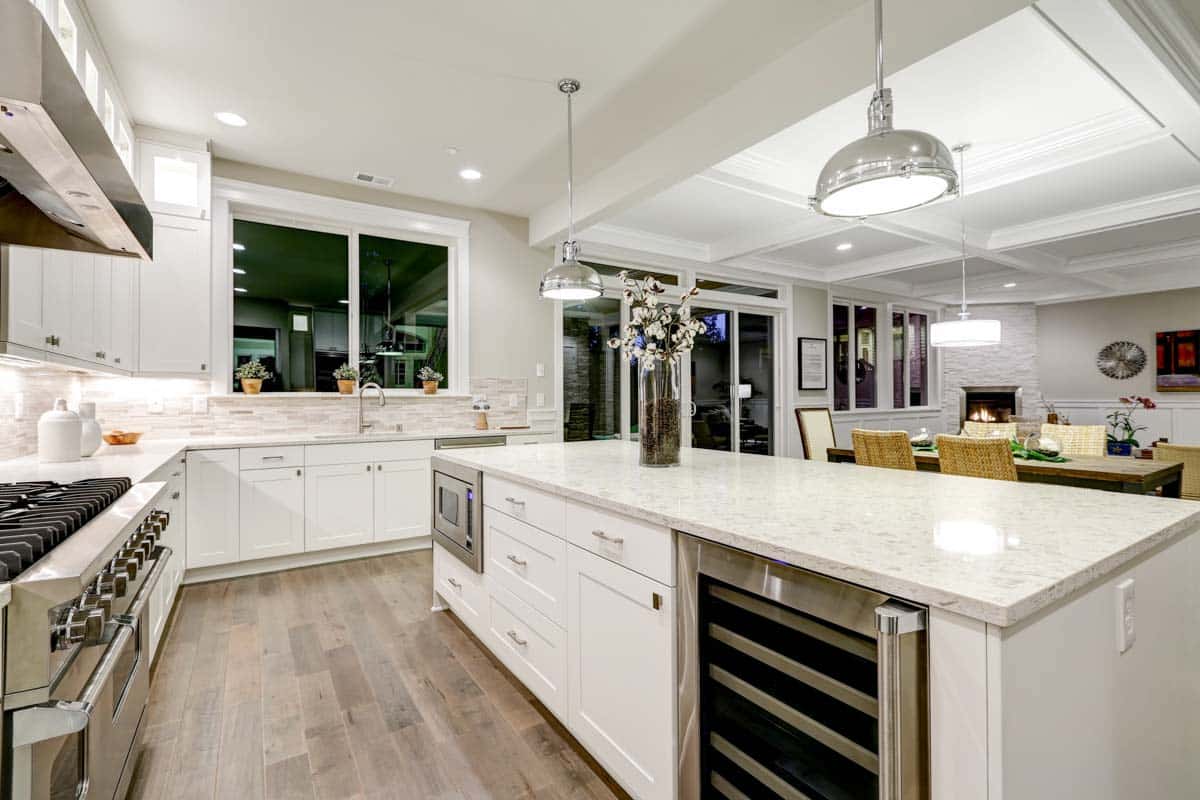 kitchen with shaker cabinets pendant lights countertop window and island