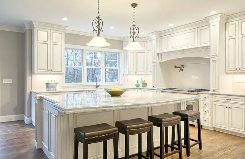Kitchen with white cabinetry island and calacatta carrara marble counters