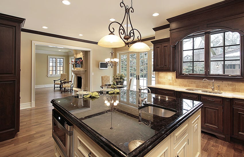 Kitchen with wood cabinets and white island with black polished countertops