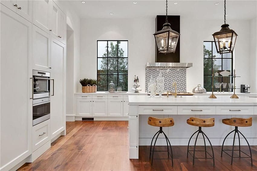 Large chefs kitchen with white cabinetry and breakfast bar seating