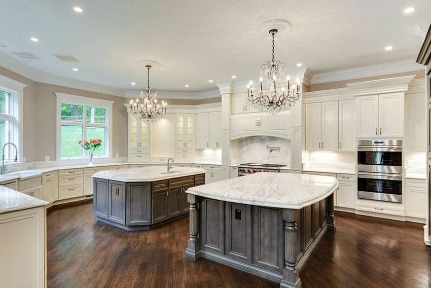 luxury kitchen with two islands chandeliers and bianco carrara marble countertops