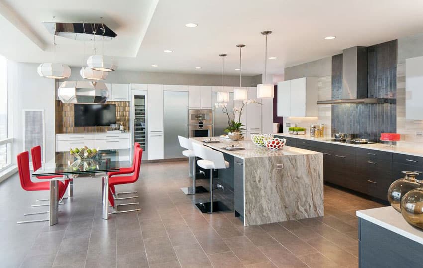 Open layout space with marble countertop and backsplash and red breakfast chairs 