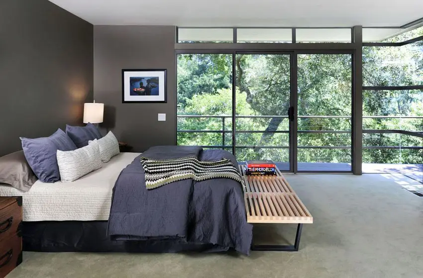 Masculine bedroom with expansive wrap around window views and dark gray paint