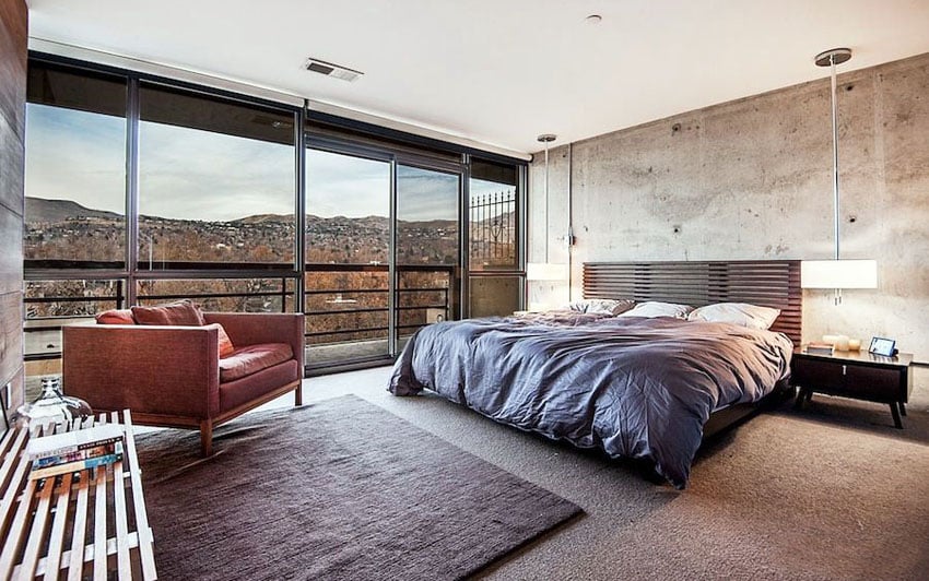 Masculine master bedroom with panoramic views, concrete walls and hanging lamps