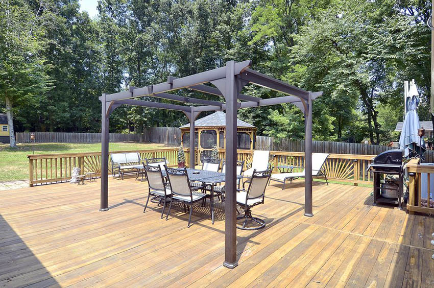 Metal pergola on backyard wood deck with outdoor dining table