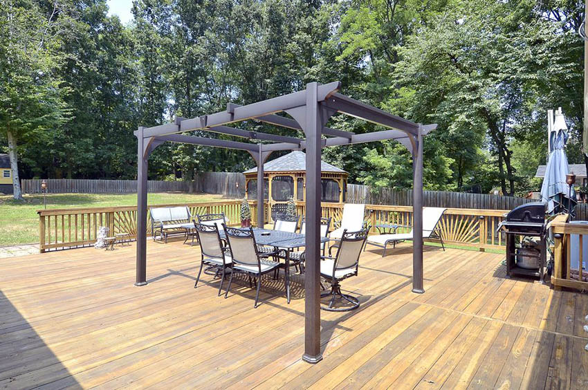 Metal pergola on wood deck witrh view of large backyard